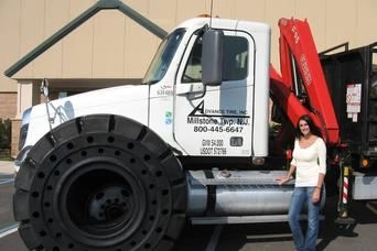 A woman standing next to a large truck.