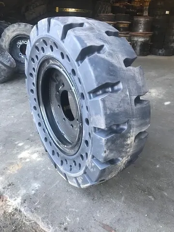 A close up of an industrial tire on the ground