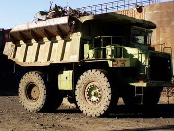 A large green dump truck with lots of metal.